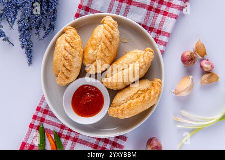 Curry puff ou Pastel goreng. c'est une petite tarte composée de curry avec du poulet et des pommes de terre dans une coquille de pâtisserie frite ou cuite au four Banque D'Images