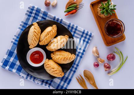 Curry puff ou Pastel goreng. c'est une petite tarte composée de curry avec du poulet et des pommes de terre dans une coquille de pâtisserie frite ou cuite au four Banque D'Images