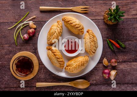 Curry puff ou Pastel goreng. c'est une petite tarte composée de curry avec du poulet et des pommes de terre dans une coquille de pâtisserie frite ou cuite au four Banque D'Images