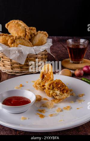 Curry puff ou Pastel goreng. c'est une petite tarte composée de curry avec du poulet et des pommes de terre dans une coquille de pâtisserie frite ou cuite au four Banque D'Images