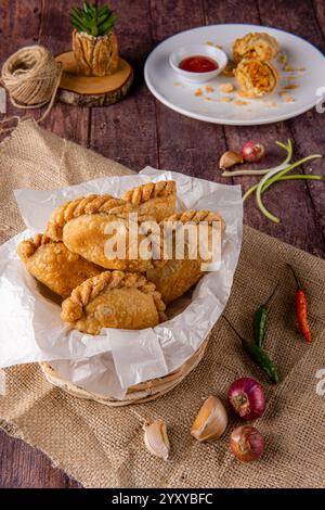 Curry puff ou Pastel goreng. c'est une petite tarte composée de curry avec du poulet et des pommes de terre dans une coquille de pâtisserie frite ou cuite au four Banque D'Images