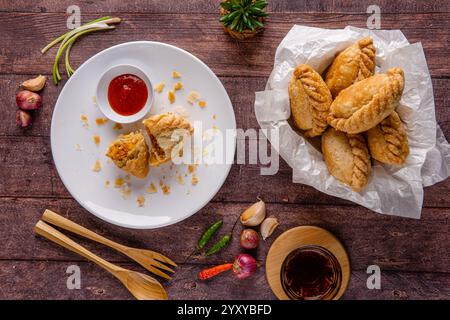 Curry puff ou Pastel goreng. c'est une petite tarte composée de curry avec du poulet et des pommes de terre dans une coquille de pâtisserie frite ou cuite au four Banque D'Images