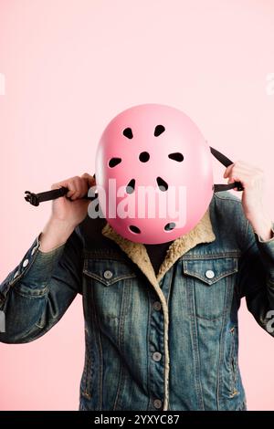 Casque de vélo, sécurité ou mains de personne en studio pour la protection, la mode ou l'esthétique. Cavalier, casque ou regardant vers le bas sur fond rose pour Banque D'Images