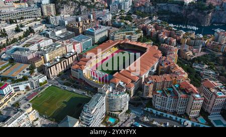 Superbe photo aérienne du stade emblématique de Monaco, entouré d'un paysage urbain dense, de bâtiments de luxe et d'espaces verts. Parfait pour le sport, les voyages Banque D'Images