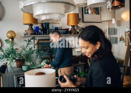 Propriétaire masculin senior et collègue féminin travaillant ensemble au magasin d'antiquités Banque D'Images
