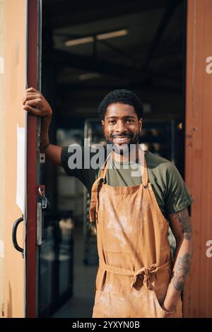 Portrait de boulanger masculin confiant debout avec la main dans la poche à la porte de la boulangerie Banque D'Images