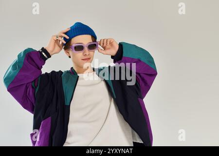 Un beau jeune homme portant une veste d'aviateur et un bonnet frappe une pose à la mode à l'intérieur. Banque D'Images