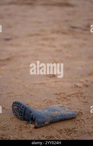 botte de gomme wellington abandonnée ou perdue sur une plage de sable à saltburn, north yorkshire, angleterre, royaume-uni Banque D'Images