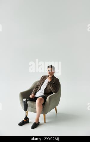 Beau jeune homme pose dans une chaise élégante tout en présentant sa jambe prothétique Banque D'Images