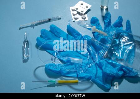 Poche de perfusion, seringue, ampoules médicales dans le fond bleu. Chambre goutte-à-goutte IV Banque D'Images