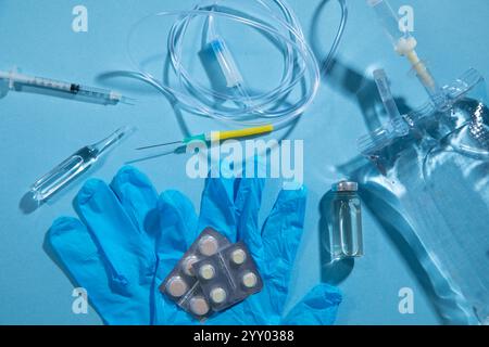 Poche de perfusion, seringue, ampoules médicales dans le fond bleu. Chambre goutte-à-goutte IV Banque D'Images