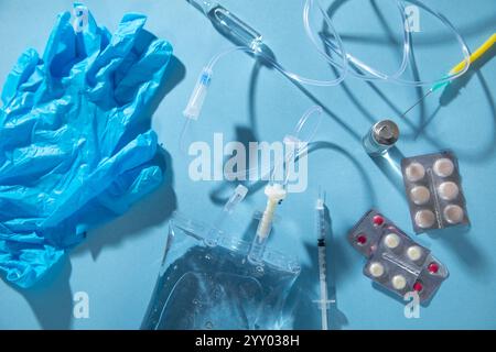 Poche de perfusion, seringue, ampoules médicales dans le fond bleu. Chambre goutte-à-goutte IV Banque D'Images