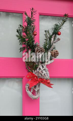 couronne de noël renne sur porte rose, norfolk, angleterre Banque D'Images