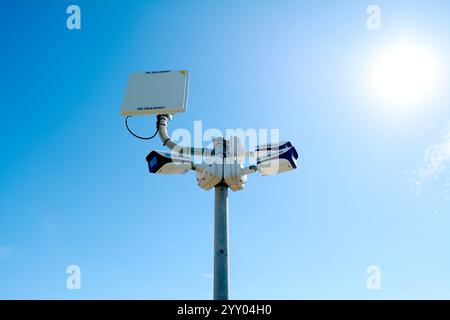 Savona, Italie - 18 décembre 2024 : caméras de sécurité modernes montées sur un poteau contre un ciel bleu vif. Représentation idéale de la surveillance, de la sécurité, Banque D'Images