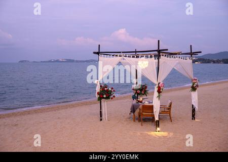 Dîner romantique sur la plage à Koh Samui au coucher du soleil Banque D'Images