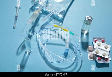 Poche de perfusion, seringue, ampoules médicales dans le fond bleu. Chambre goutte-à-goutte IV Banque D'Images