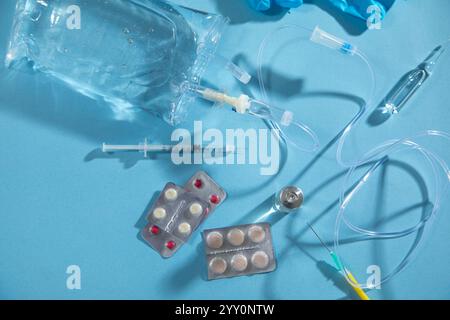 Poche de perfusion, seringue, ampoules médicales dans le fond bleu. Chambre goutte-à-goutte IV Banque D'Images