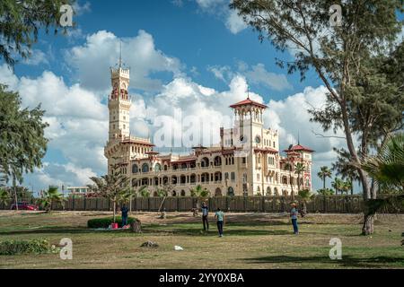 Montaza Palace à Alexandrie, en Égypte, présente une architecture étonnante entourée de verdure luxuriante sous un ciel vibrant, créant un paysage historique. Banque D'Images