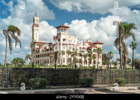 Majestueux Palais Montaza, Alexandrie, Egypte, entouré de palmiers sous un ciel spectaculaire. Architecture historique, jardins luxuriants et monument emblématique. Banque D'Images