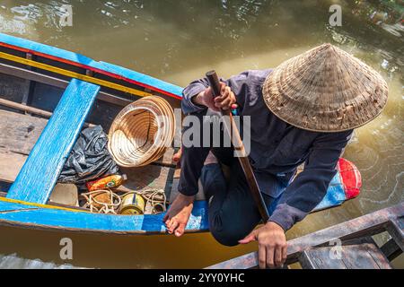 Vietnam, 2024-03-02, delta du Mékong, chapeau de paille vietnamien, pagaie, bateau, rames, bateau en bois bleu, traditionnel, touristes Banque D'Images