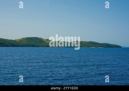 La côte ionienne près de Ksamil, une partie de la Riviera albanaise. Ici, les collines verdoyantes de la chaîne de montagnes Ceraunian rencontrent le détroit de Corfou Banque D'Images