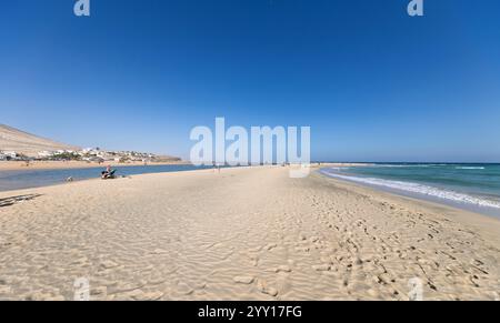 TIERRA DORADA, ESPAGNE - 4 DÉCEMBRE : (NOTE DE LA RÉDACTION : un filtre de couleur graduée a été utilisé pour cette image.) Les touristes prennent le soleil entre les lagunes et l'océan à Playa de Sotavento de Jandía le 4 décembre 2024 à Tierra Dorada, Espagne. Banque D'Images