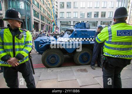 Des policiers effectuent des perquisitions lors de la manifestation du G20 à Londres, au Royaume-Uni, le groupe de protestation Space Hijackers a conduit un véhicule blindé de transport de troupes Alvis Saracen dans la ville de Londres. Le groupe a utilisé le véhicule comme symbole de protestation contre les institutions financières et les politiques gouvernementales, visant à perturber les activités normales de la ville et à attirer l'attention sur leur message anticapitaliste. Banque D'Images