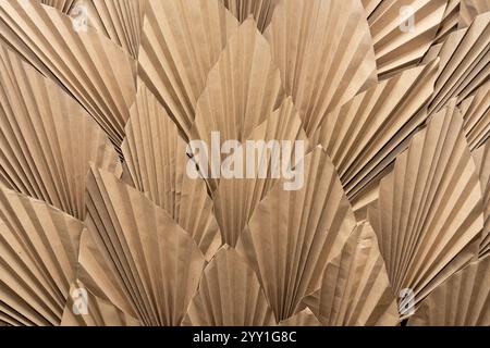 Cette œuvre affiche un arrangement texturé de papier brun plié, ressemblant à des feuilles dans un motif naturel. Le design complexe met en valeur les artisans Banque D'Images