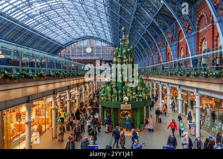 Londres, Angleterre, Royaume-Uni - 18 décembre 2024 : vue sur le toit en verre emblématique du Groupe Pancras International et le sapin décoré de Noël Banque D'Images