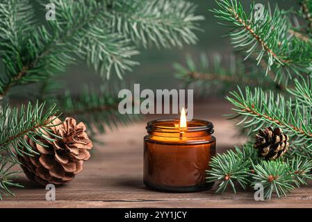 Bougies parfumées et braches de sapin. Bougie Birning avec pin, ambiance de Noël confortable d'hiver, concept hygge. Banque D'Images
