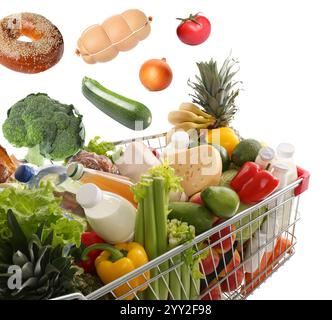 Épicerie tombant dans le panier sur fond blanc Banque D'Images