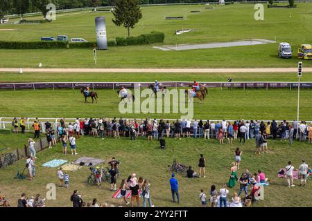 Wroclaw, Pologne- Maj 3, 2024 : spectateurs regardant des cavaliers sur une piste de course lors d'un événement en plein air, dans une atmosphère familiale Banque D'Images