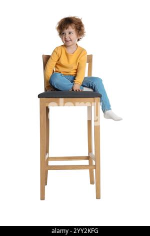 Petit garçon assis sur le tabouret sur fond blanc Banque D'Images