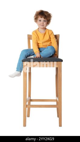 Petit garçon assis sur le tabouret sur fond blanc Banque D'Images