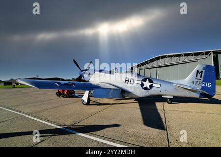 Chasseur américain de la seconde Guerre mondiale le P-51 Mustang nord-américain à Duxford avec ciel sombre et rayons de soleil Banque D'Images