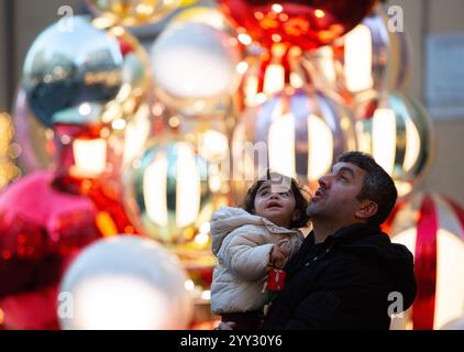 Rome, Italie. 17 décembre 2024. Les gens regardent un arbre de Noël à Rome, Italie, Dec. 17, 2024. Crédit : Li Jing/Xinhua/Alamy Live News Banque D'Images