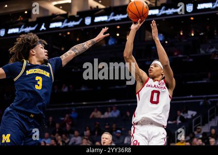 Charlotte, Caroline du Nord, États-Unis. 18 décembre 2024. Oklahoma Sooners garde Jeremiah Fears (0) tourne sur le gardien Michigan Wolverines Tre Donaldson (3) pendant la première moitié de l'invitation Jumpman 2024 au Spectrum Center à Charlotte, Caroline du Nord. (Scott Kinser/CSM). Crédit : csm/Alamy Live News Banque D'Images