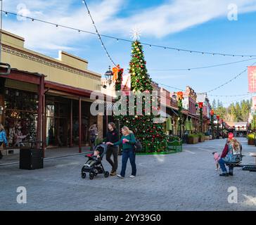 Une famille passe devant le sapin de Noël décoré sur Mill Street, une rue piétonne dans le centre-ville historique de cette ville des contreforts de la Sierra. Banque D'Images