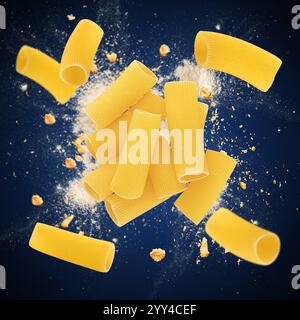 Pâtes rigatoni crues explosant sur un fond bleu, créant un concept alimentaire dynamique Banque D'Images