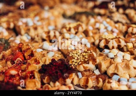 Une gamme colorée de desserts délicieux exposés dans une pâtisserie gaufres garnies de fruits, chocolat et guimauves créent une scène tentante de Banque D'Images