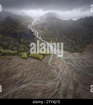 Vue aérienne captivante d'un delta du fleuve islandais des montagnes brumeuses apparaissent en arrière-plan, rehaussant l'atmosphère dramatique et mystique du paysage Banque D'Images