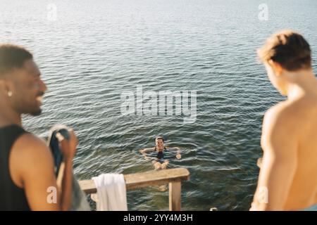 Vue en angle élevé de la femme souriante nageant dans la mer à la journée ensoleillée Banque D'Images