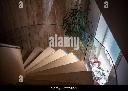 Escalier intérieur moderne en spirale en bois dans un intérieur lumineux à l'intérieur d'un manoir résidentiel spacieux. Banque D'Images