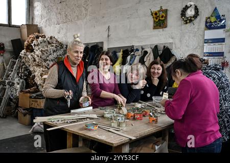 Non exclusif : ZAPORIZHZHIA, UKRAINE - 17 DÉCEMBRE 2024 - la volontaire Valentyna Tyshkevych (l) fabrique des bougies tranchées pour les Forces armées ukrainiennes à Banque D'Images