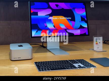 Paris, France - 10 décembre 2024 : le Mac Studio associé au Studio Display, doté d'un design élégant, d'un Magic Keyboard et d'un Magic Trackpad, exposé sur une table en bois dans un Apple Store. Banque D'Images