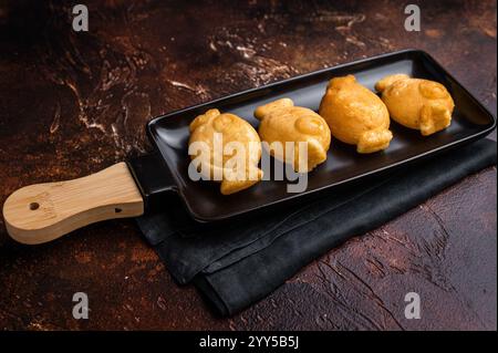 Gaufre japonaise en forme de poisson Taiyaki avec pâte sucrée. fond marron. vue de dessus. Banque D'Images