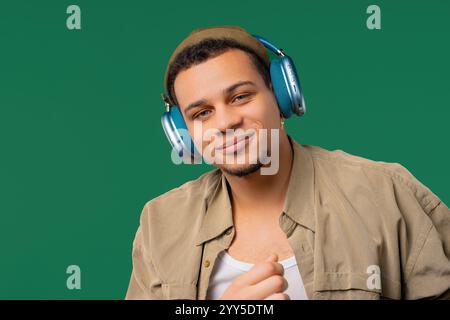 Homme de race mixte positif écoutant de la musique, profitant de la danse avec des écouteurs modernes Banque D'Images