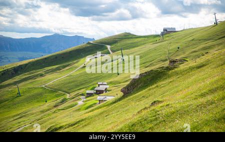 Collines verdoyantes couvertes de pentes douces et herbeuses avec un chemin courbe le long de celle-ci, Seceda, Dolomites, Italie Banque D'Images