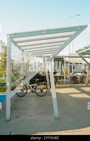 parking avec supports de vélos en tubes torsadés brillants, pour insérer et verrouiller le vélo sur la place. pavage à emboîtement et granit Banque D'Images