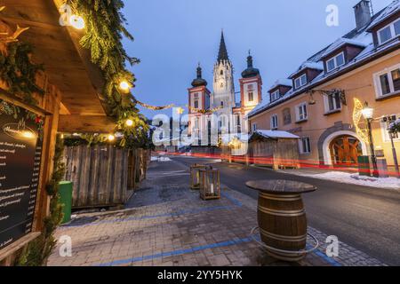 Ambiance de l'Avent, rue éclairée de Noël avec des traînées de lumières, façade de la basilique derrière, heure bleue au petit matin, Mariazell, Styrie, Austr Banque D'Images